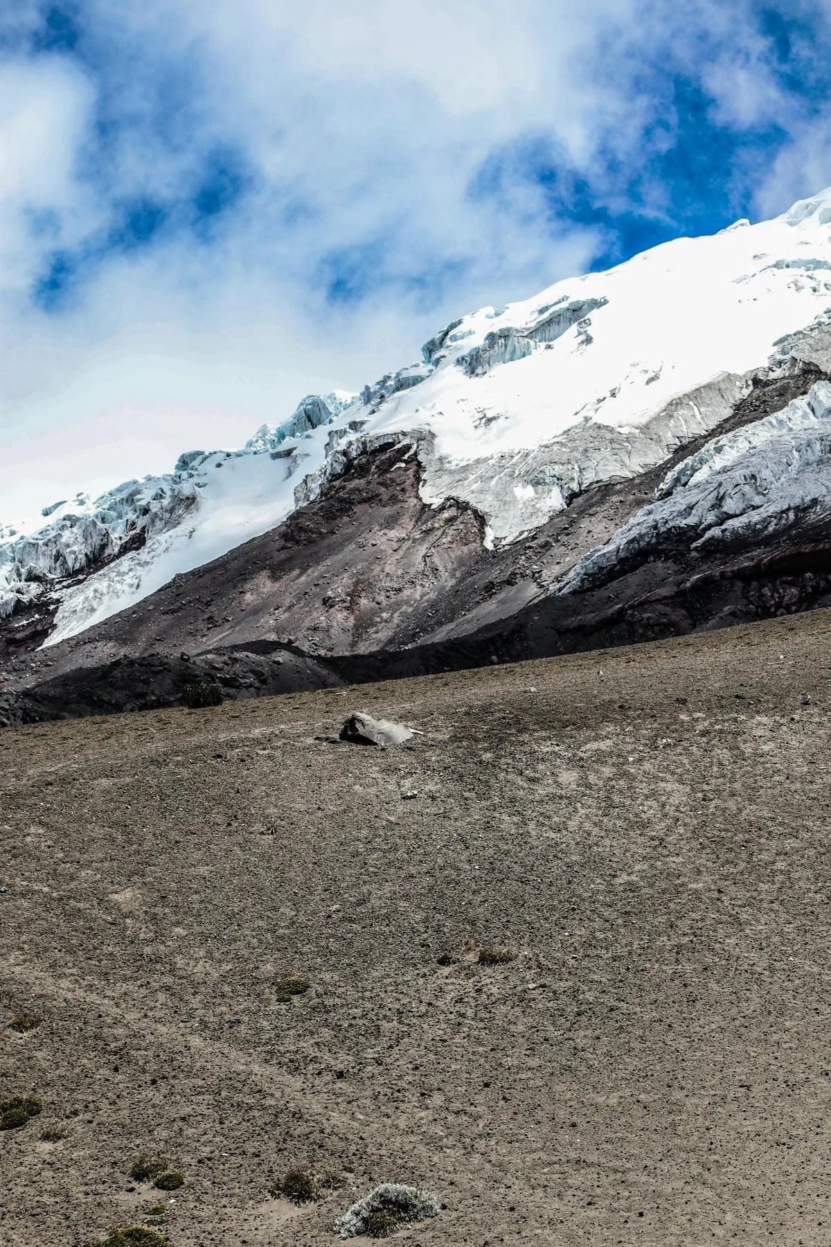 Snow-capped mountain peak under blue sky, like Nevado del Ruiz on the horizon