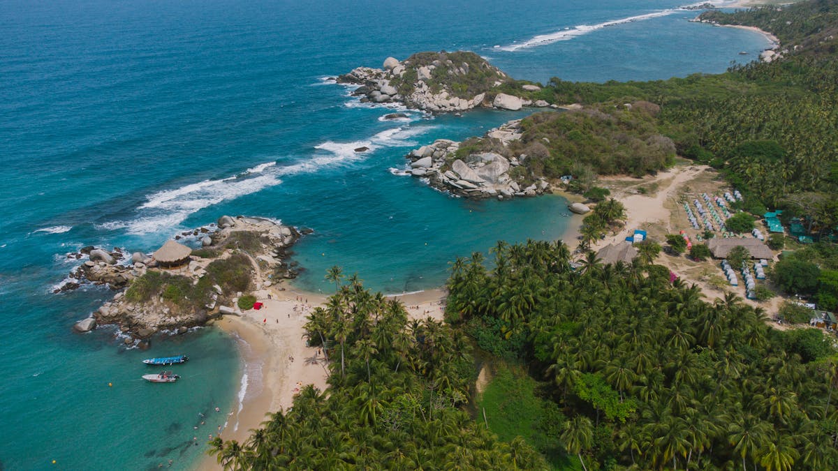 Aerial view of a pristine beach in Tayrona National Park with turquoise water and lush jungle
